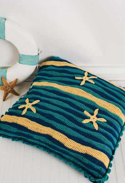 Uma almofada de crochê com motivos praianos