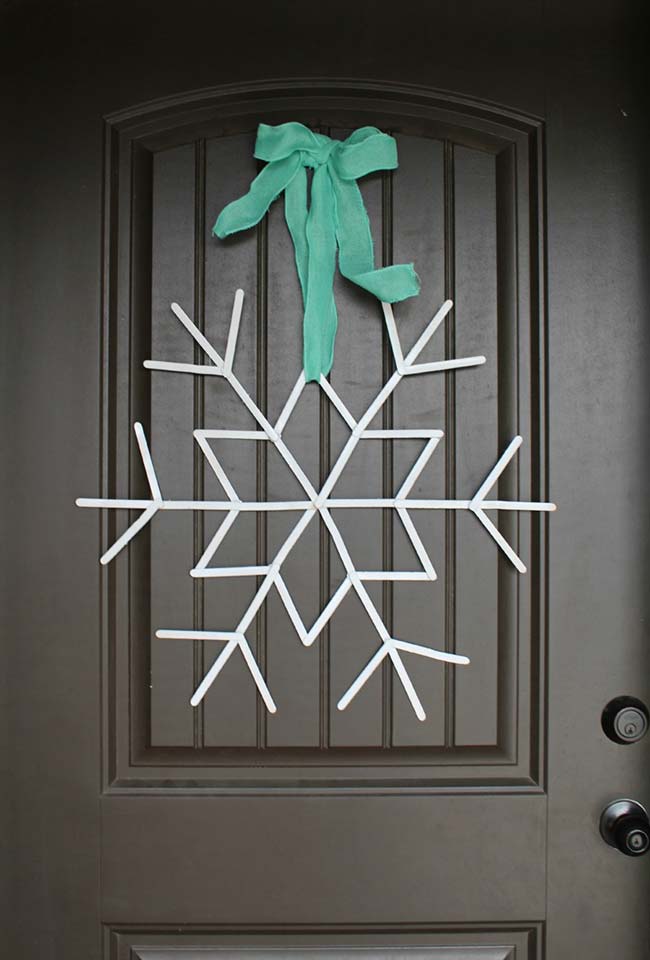 Palitos de picolé formam o floco de neve que enfeita a porta