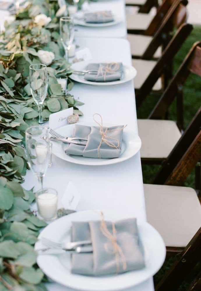 Faça uma decoração com folhas para colocar em cima da mesa de jantar e coloque os talheres dentro de um tecido amarrado por um fio.