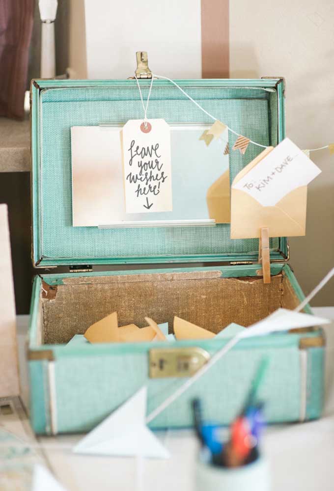Use uma mala pequena e antiga para os convidados deixarem mensagens para os noivos.