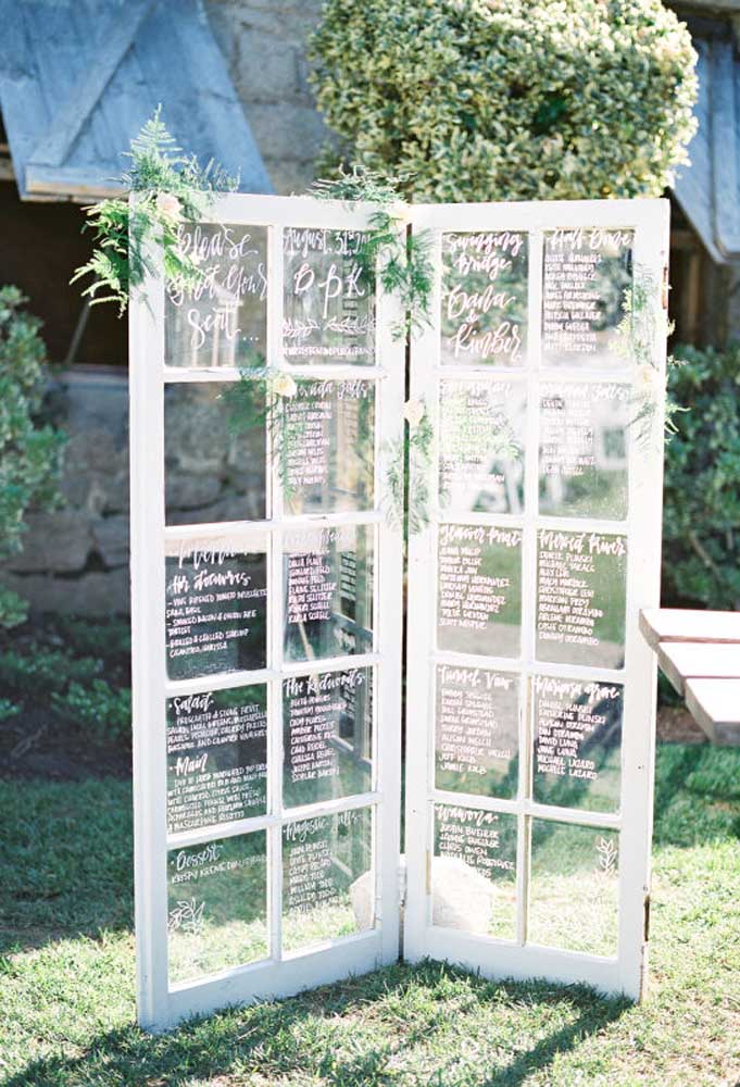 Uma porta antiga feita de madeira e vidro pode servir como objeto de decoração de um casamento rústico.